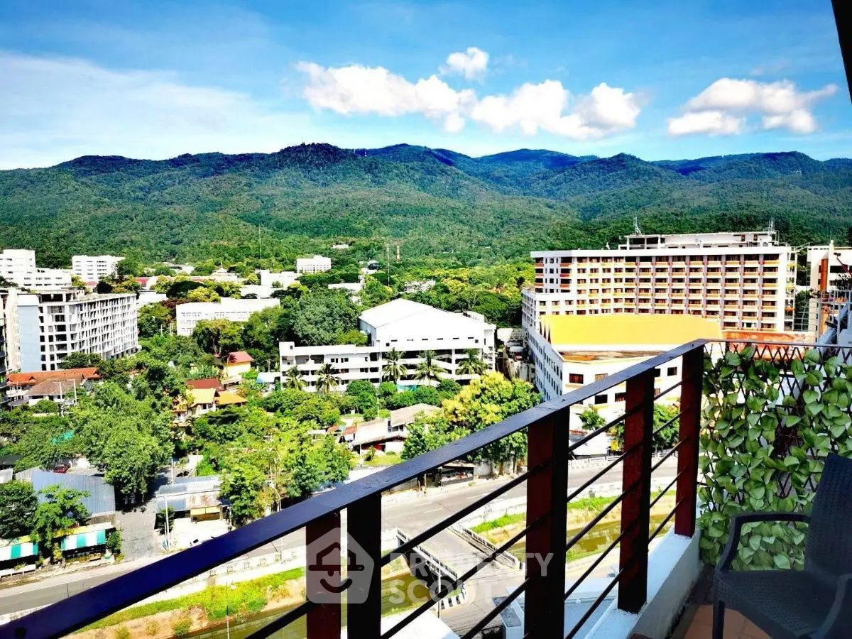 Stunning balcony view of lush mountains and cityscape, perfect for relaxation and enjoying nature.