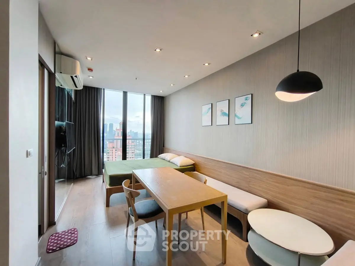 Modern studio apartment with city view, featuring a cozy living area and stylish decor.