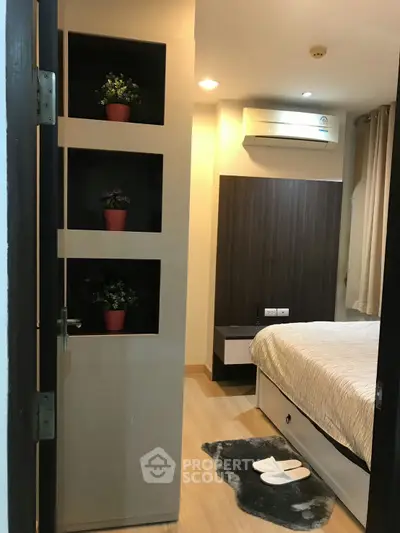 Cozy bedroom with modern decor and air conditioning, perfect for relaxation.