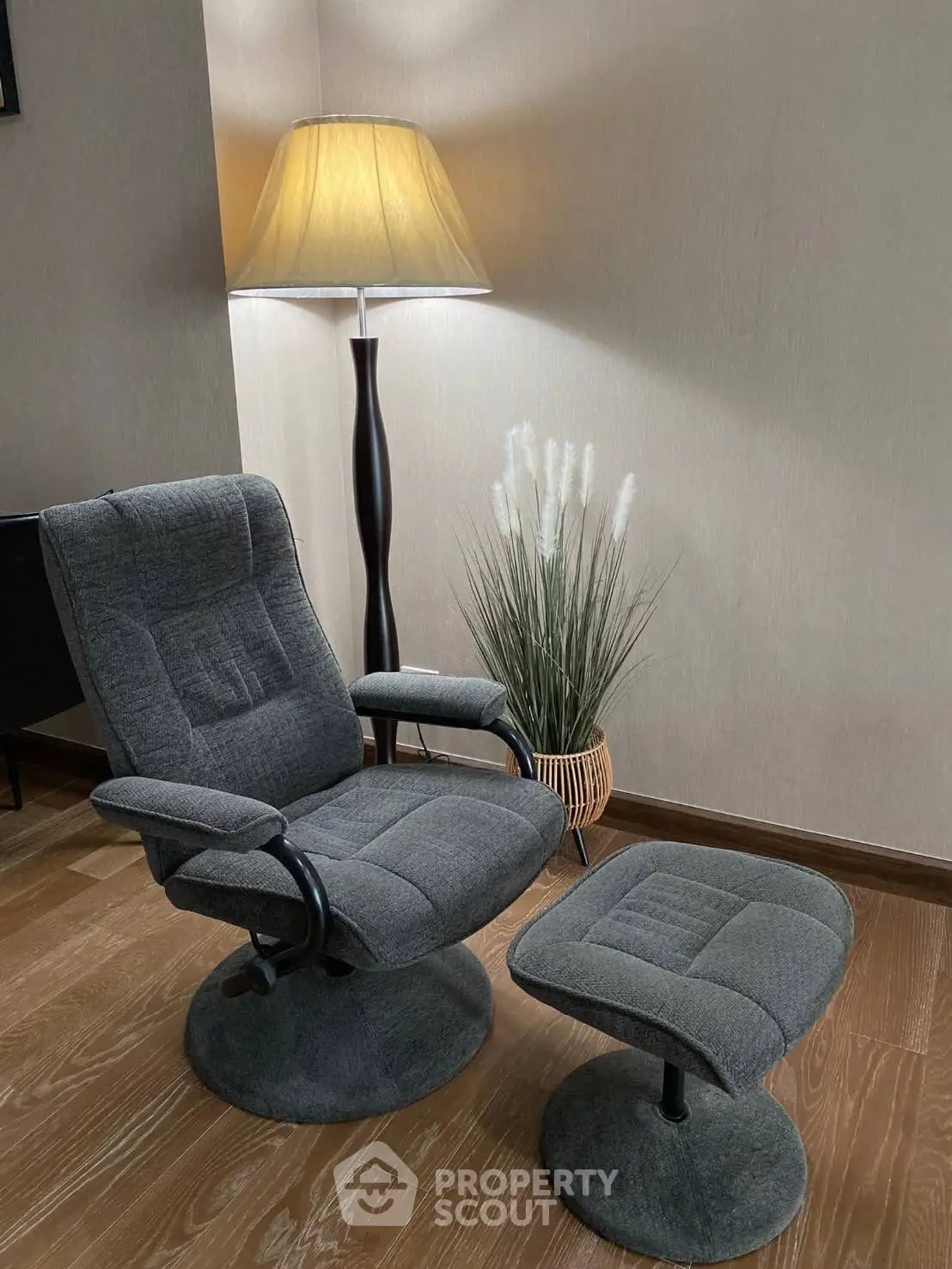 Cozy living room corner with modern armchair and ottoman, perfect for relaxation.