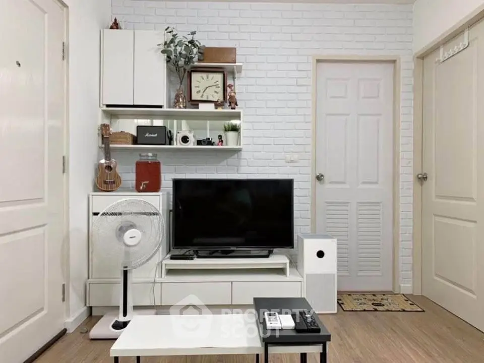 Charming living room with modern decor, featuring a TV, fan, and stylish shelving on a white brick wall.