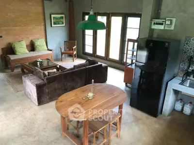 Charming rustic living room with cozy seating and modern kitchen appliances, perfect for relaxation and entertaining.