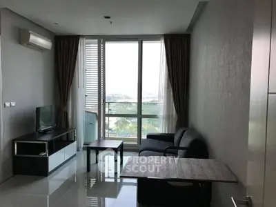 Modern living room with large windows and sleek furniture in a high-rise apartment.