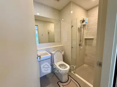 Modern bathroom with glass shower and sleek fixtures in a contemporary apartment.
