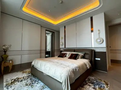 Luxurious modern bedroom with elegant lighting and plush bedding in a high-end apartment.