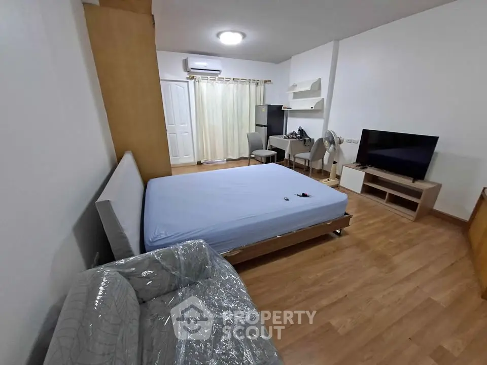 Spacious bedroom with modern furnishings and natural light, featuring a comfortable bed and stylish decor.