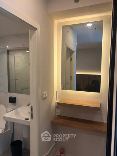 Modern bathroom with illuminated mirror and sleek fixtures in a contemporary apartment.