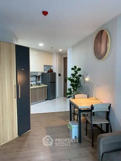 Modern apartment interior with open kitchen and dining area, featuring stylish furniture and decor.
