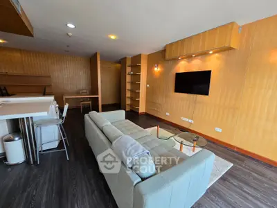 Spacious modern living room with sleek design and open layout, featuring a cozy sofa and wall-mounted TV.