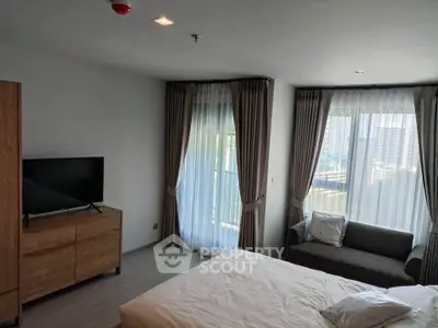 Spacious bedroom with modern decor and large windows offering city views