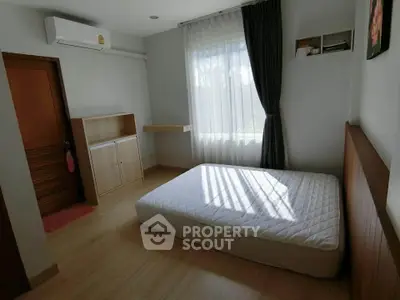 Cozy bedroom with natural light, featuring a minimalist design and air conditioning for comfort.