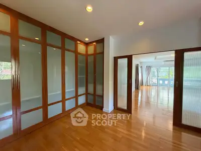 Spacious interior with elegant wooden flooring and glass-paneled doors, perfect for modern living.