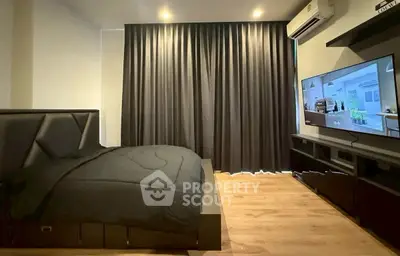 Modern bedroom with sleek design, featuring a large bed and wall-mounted TV, perfect for relaxation.