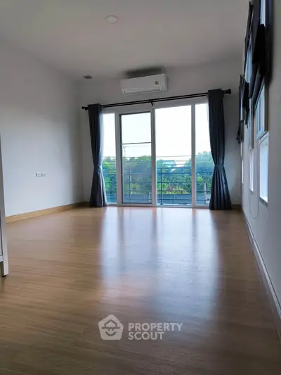 Spacious empty room with large windows and balcony view, perfect for customization.