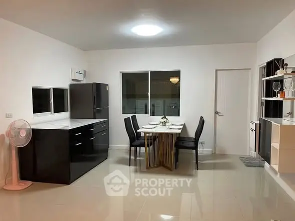 Modern kitchen with sleek black cabinets and dining area in open layout