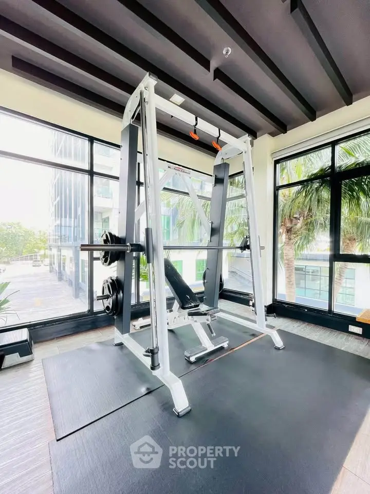 Modern gym with state-of-the-art equipment and large windows offering a scenic view.