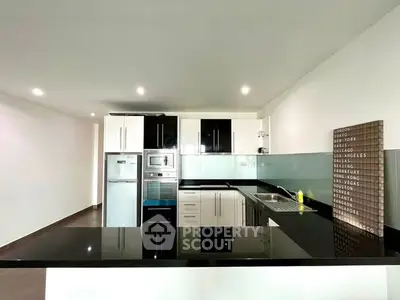 Modern kitchen with sleek black countertops and stainless steel appliances