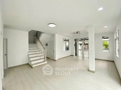 Spacious modern living room with staircase and large windows for natural light