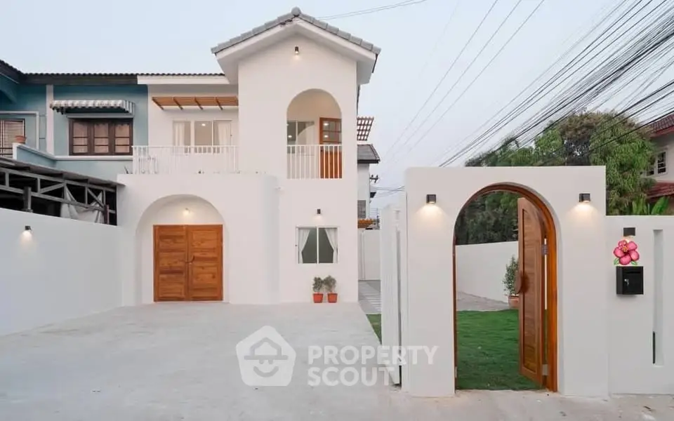 Charming two-story white house with wooden accents and gated entrance, perfect for modern family living.