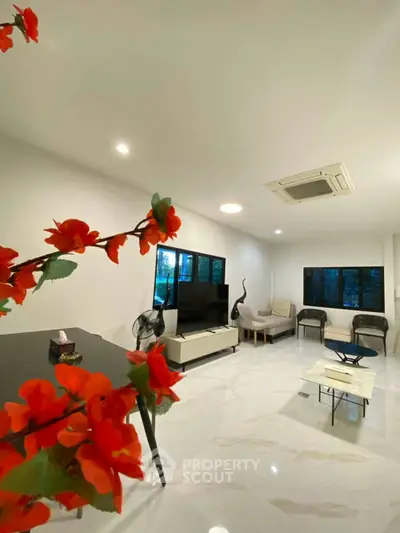 Spacious modern living room with elegant decor and large windows offering natural light.