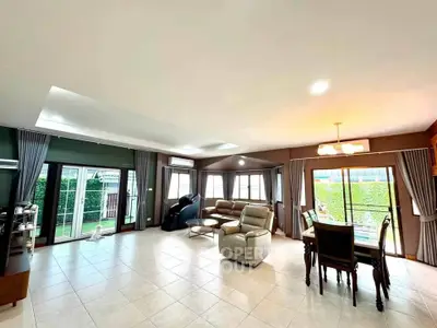 Spacious living room with large windows and elegant dining area, perfect for family gatherings.