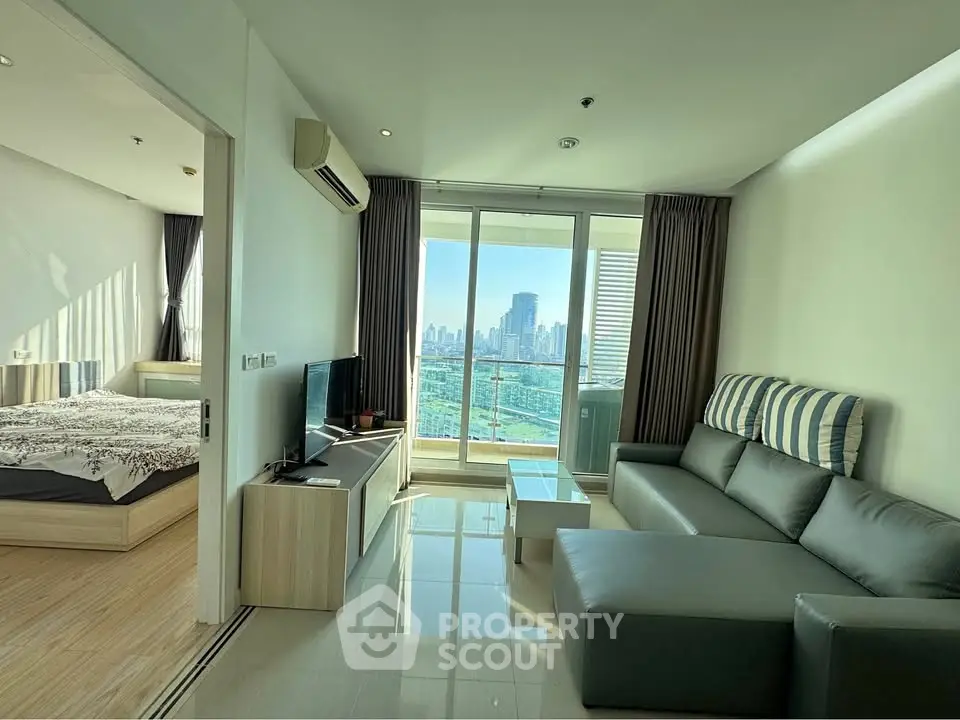 Modern living room with city view and balcony access in high-rise apartment.