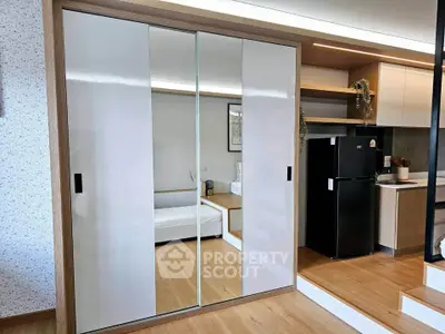Modern apartment interior with mirrored sliding doors and sleek kitchen design