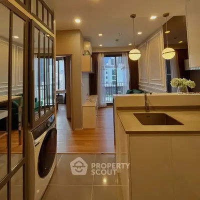 Modern open-layout kitchen with sleek design and city view, featuring elegant lighting and stylish decor.