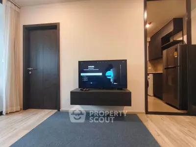 Modern living room with wall-mounted TV and sleek kitchen view