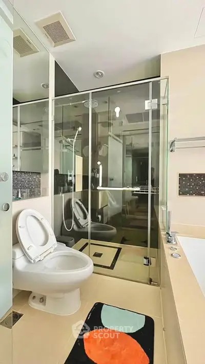 Modern bathroom with glass shower, bathtub, and stylish decor