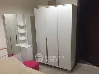 Modern bedroom with sleek white wardrobe and mirror, perfect for stylish storage solutions.