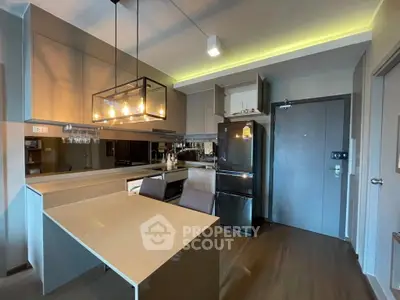 Modern kitchen with sleek design, featuring a stylish light fixture and open layout for contemporary living.