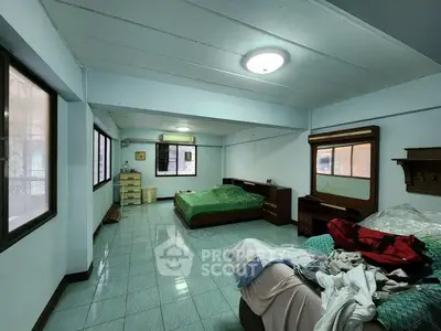 Spacious bedroom with ample natural light and minimalist furnishings, ideal for comfortable living.