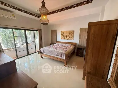 Spacious bedroom with elegant wooden furniture and large windows overlooking lush greenery.