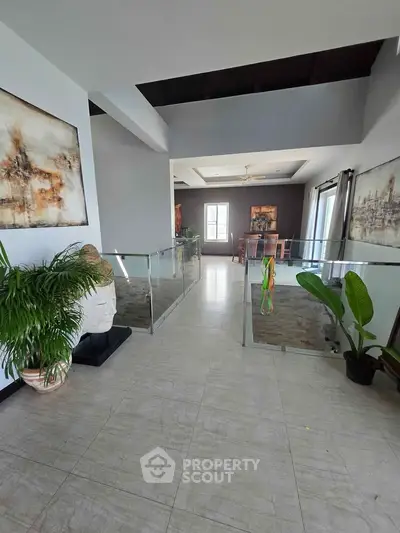 Spacious modern interior with elegant decor and natural light, featuring a stylish dining area and lush indoor plants.