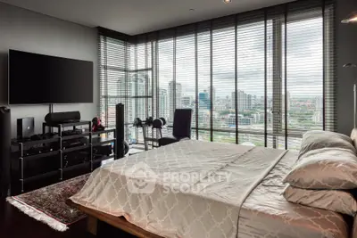 Luxurious bedroom with stunning city view and modern entertainment setup.