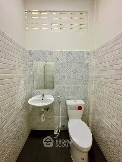 Compact bathroom with modern fixtures and stylish tile design.