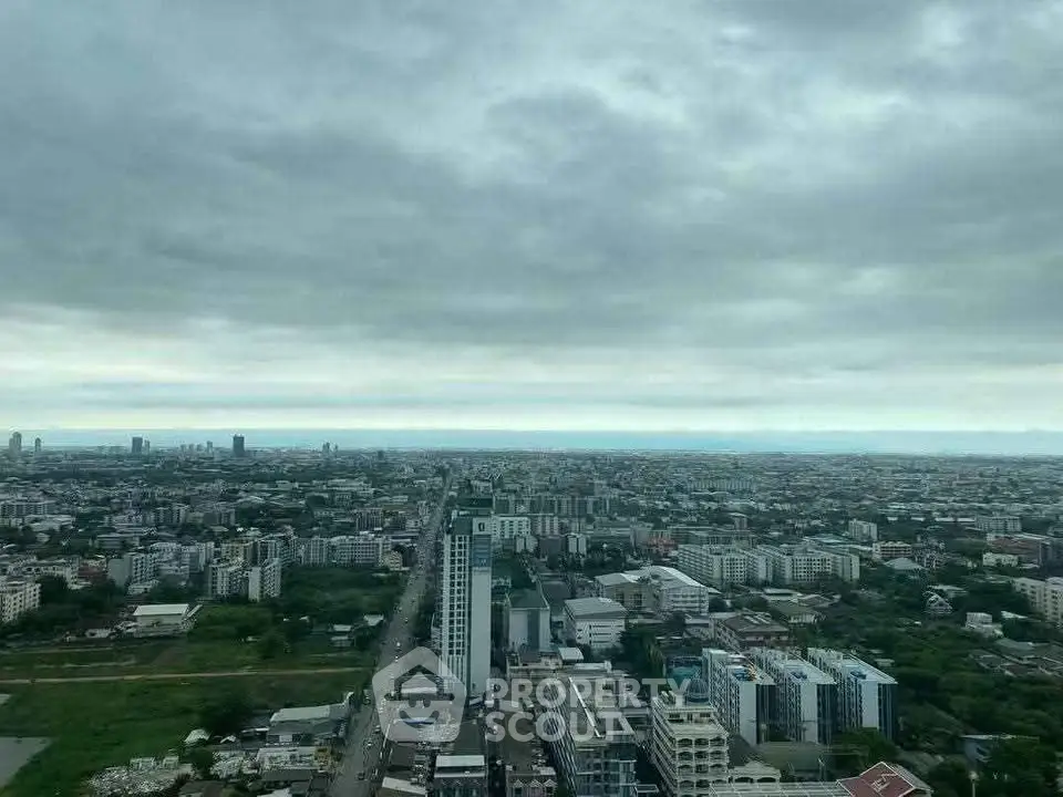 Stunning panoramic cityscape view from high-rise building, showcasing urban skyline under dramatic cloudy skies.