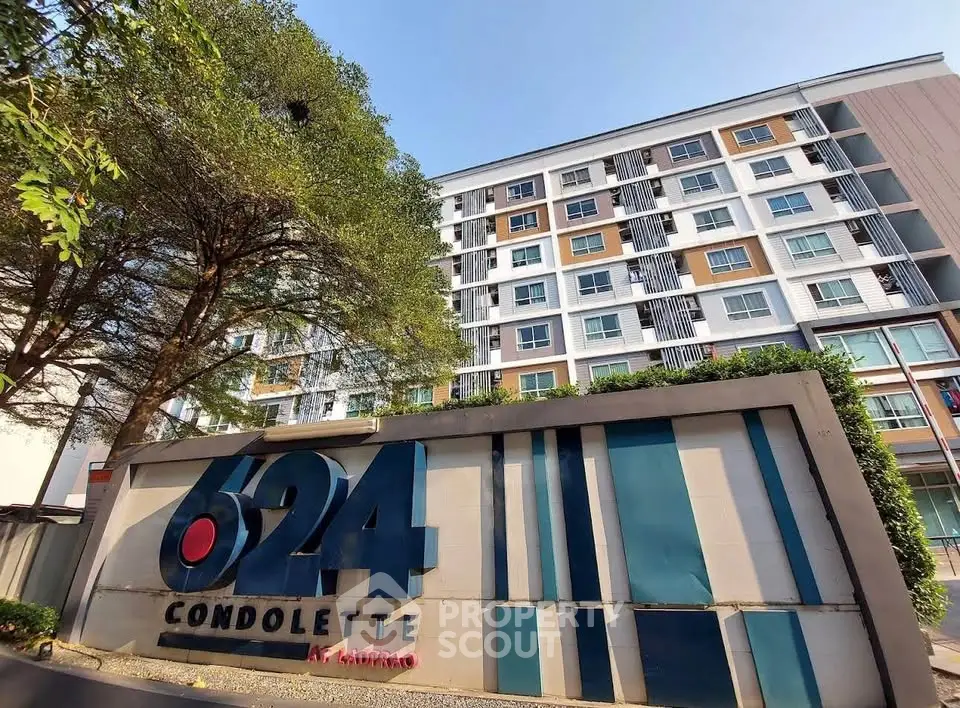 Modern condominium building with stylish facade and lush greenery