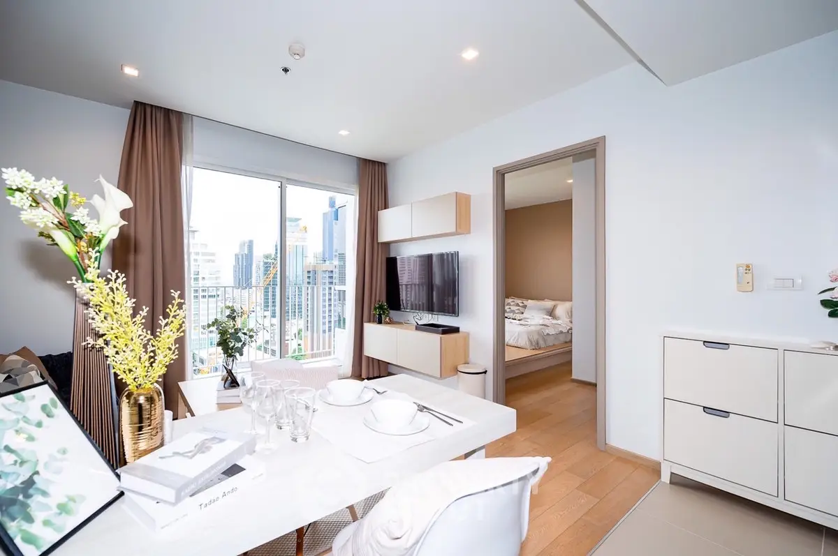 Modern apartment interior with open living and dining area, featuring a city view balcony.
