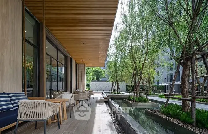Modern outdoor seating area with stylish furniture and lush greenery in a luxury property setting.