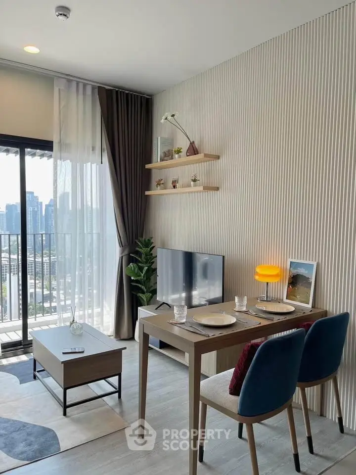 Modern living room with city view, stylish decor, and dining area in a high-rise apartment.