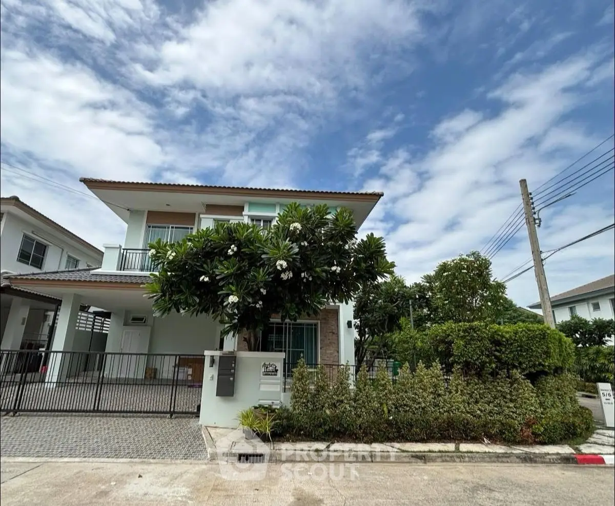 Charming two-story house with lush garden and spacious driveway in a serene neighborhood.