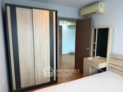Modern bedroom with wooden wardrobe and air conditioning in a stylish apartment.