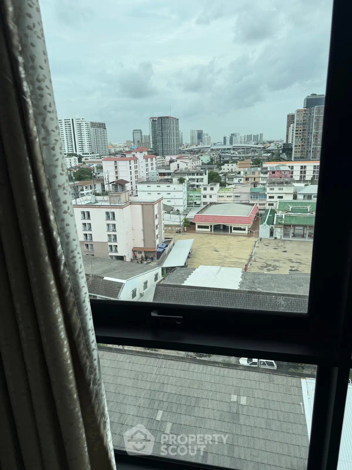 Stunning cityscape view from a high-rise apartment window, showcasing urban skyline and vibrant neighborhood.
