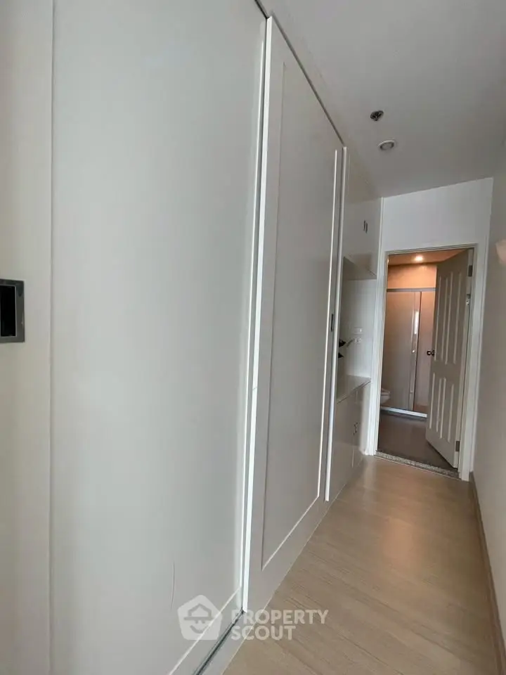 Modern hallway with sleek storage and wooden flooring in a contemporary apartment.