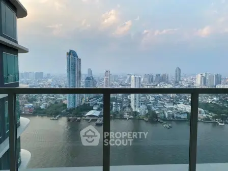 Stunning high-rise balcony view overlooking a vibrant cityscape and river, perfect for urban living.