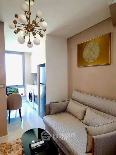 Modern living room with elegant chandelier and cozy sofa, adjacent to a bright dining area.