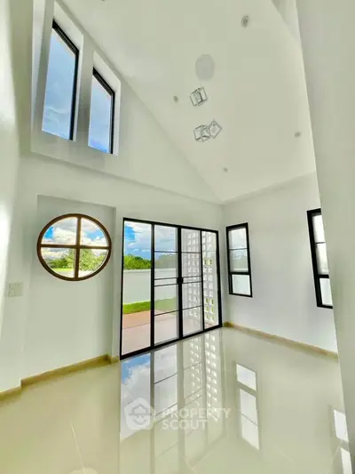 Stunning modern living room with high ceilings and large windows offering natural light and scenic views.
