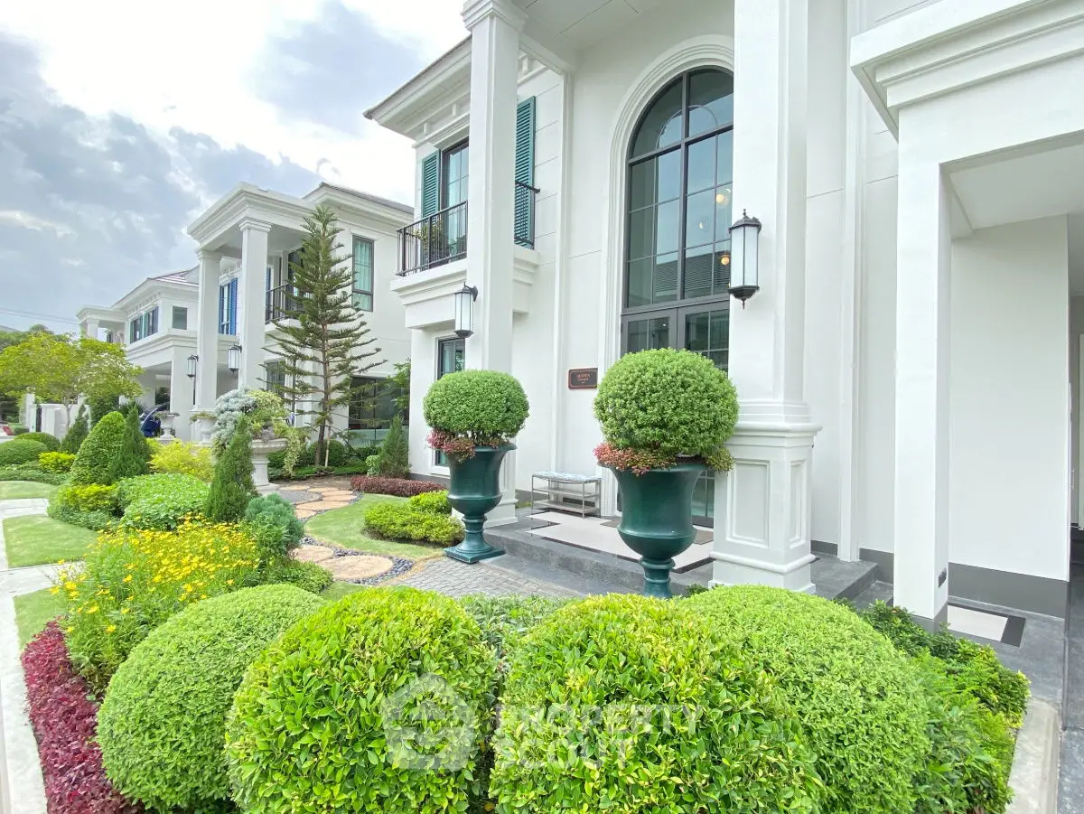Luxurious white mansion exterior with elegant landscaping and grand entrance